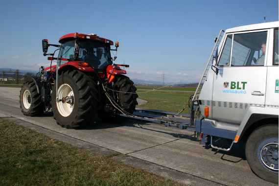 A Tractor drives on the road with a brake truck (Pulling power with a brake truck)