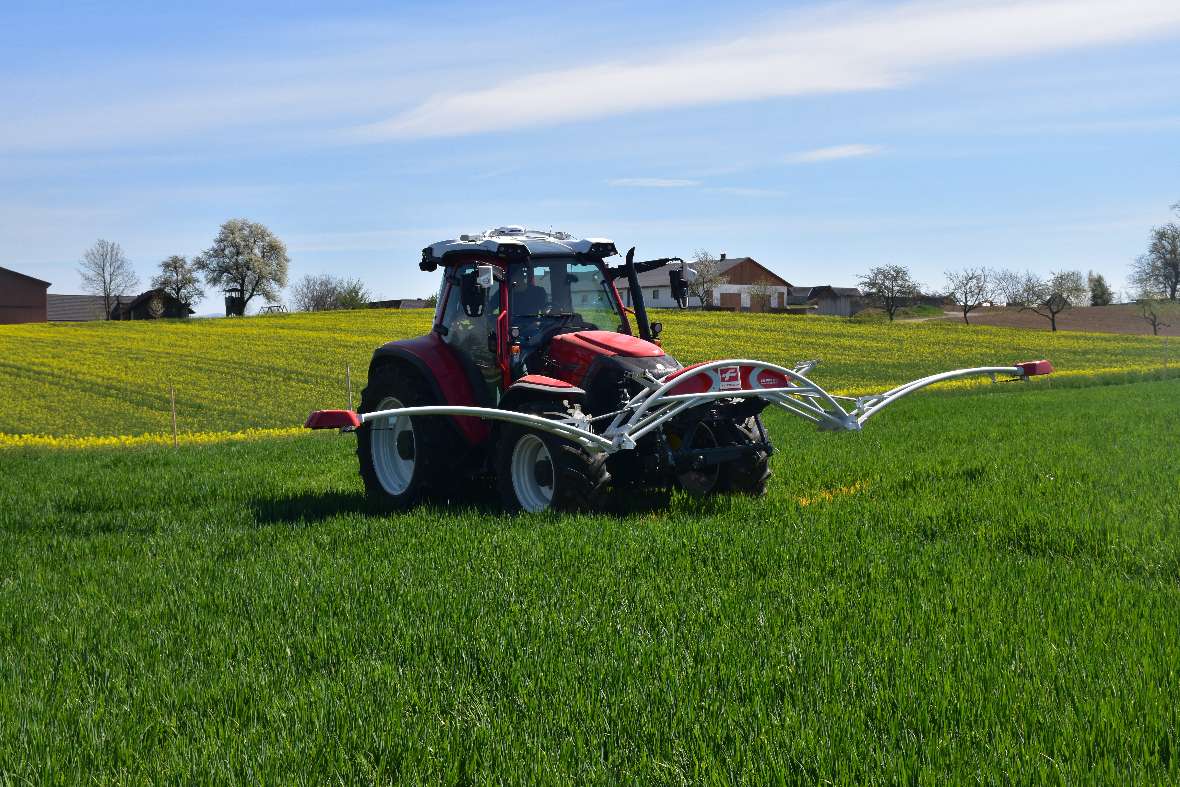 Tractor with a front implement on the test field (Fertilization and plant protection)