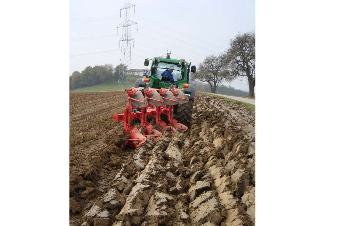 A tractor with a plow drives in the field (Measurement technology tractor)