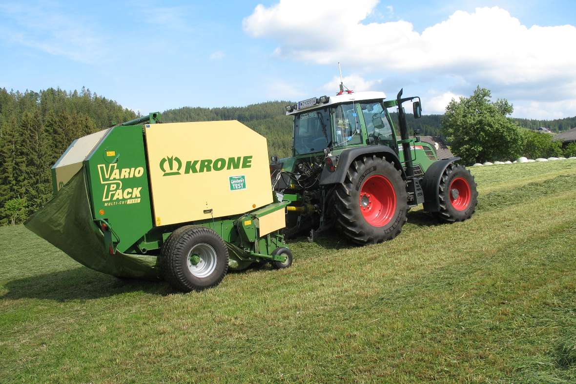 A tractor drives a baler in a meadow (Measurement technology tractor)