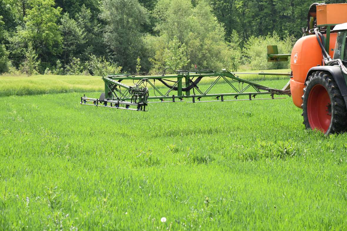 Tractor with a sprayer on a meadow